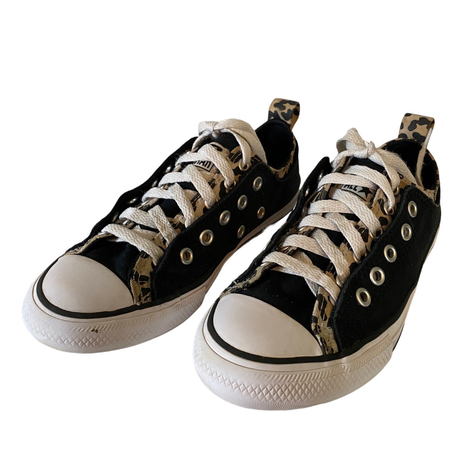 Black sneakers with white soles and leopard print accents on a white background