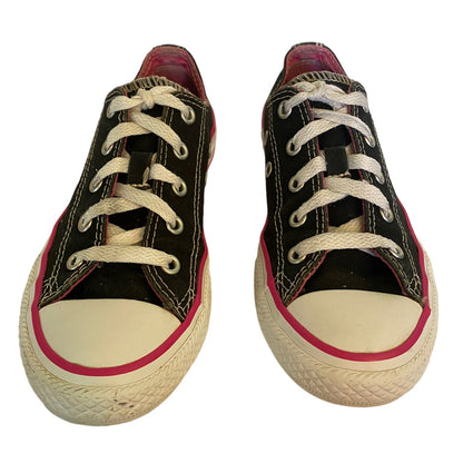 Black low top sneakers with white and pink trim on a white background