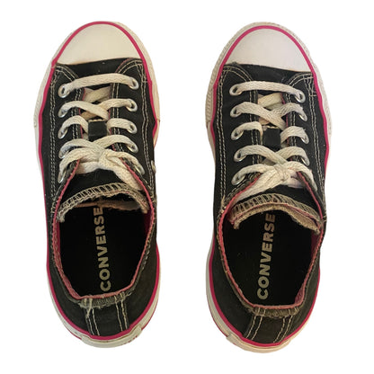 Top view of black with pink and white trim converse sneakers on a white background