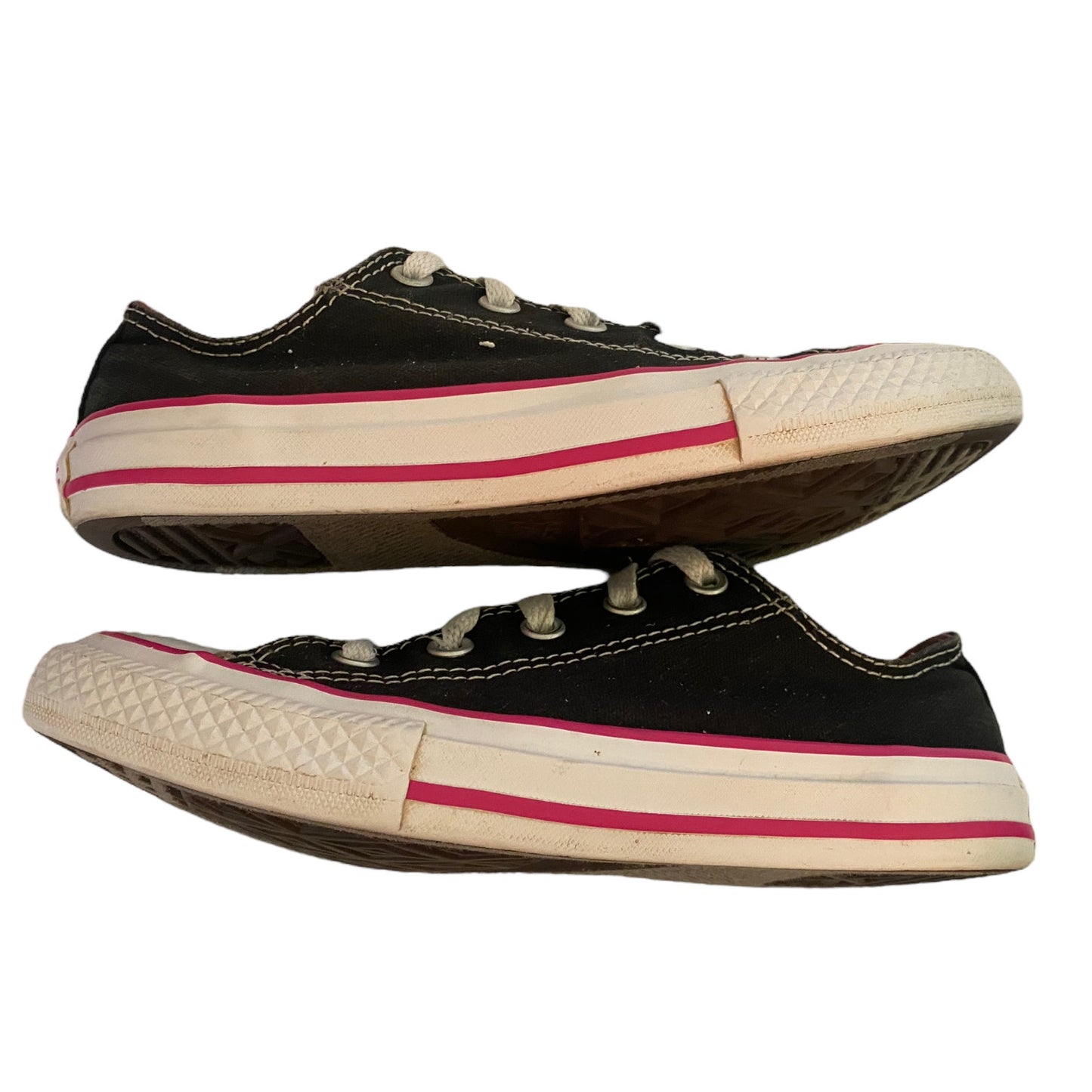 Side view of black sneakers with white and pink trim on a white background