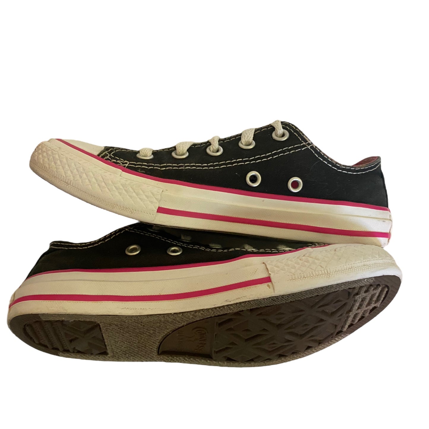 Black low top sneakers with white and pink trim on a white background