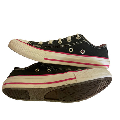 Black low top sneakers with white and pink trim on a white background