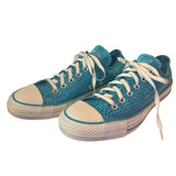 Front side of a Pair of blue sneakers with white laces on a white background