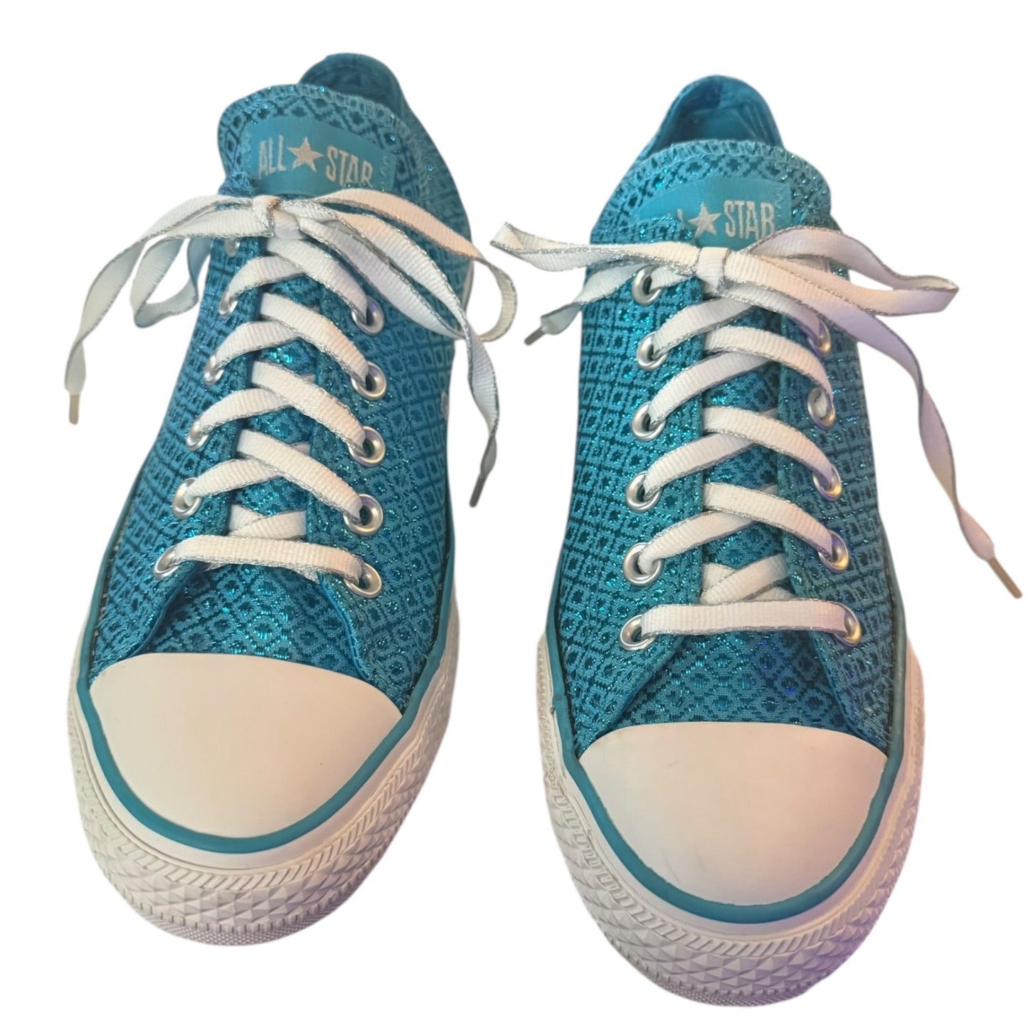 Front of a Pair of blue sneakers with white laces on a white background