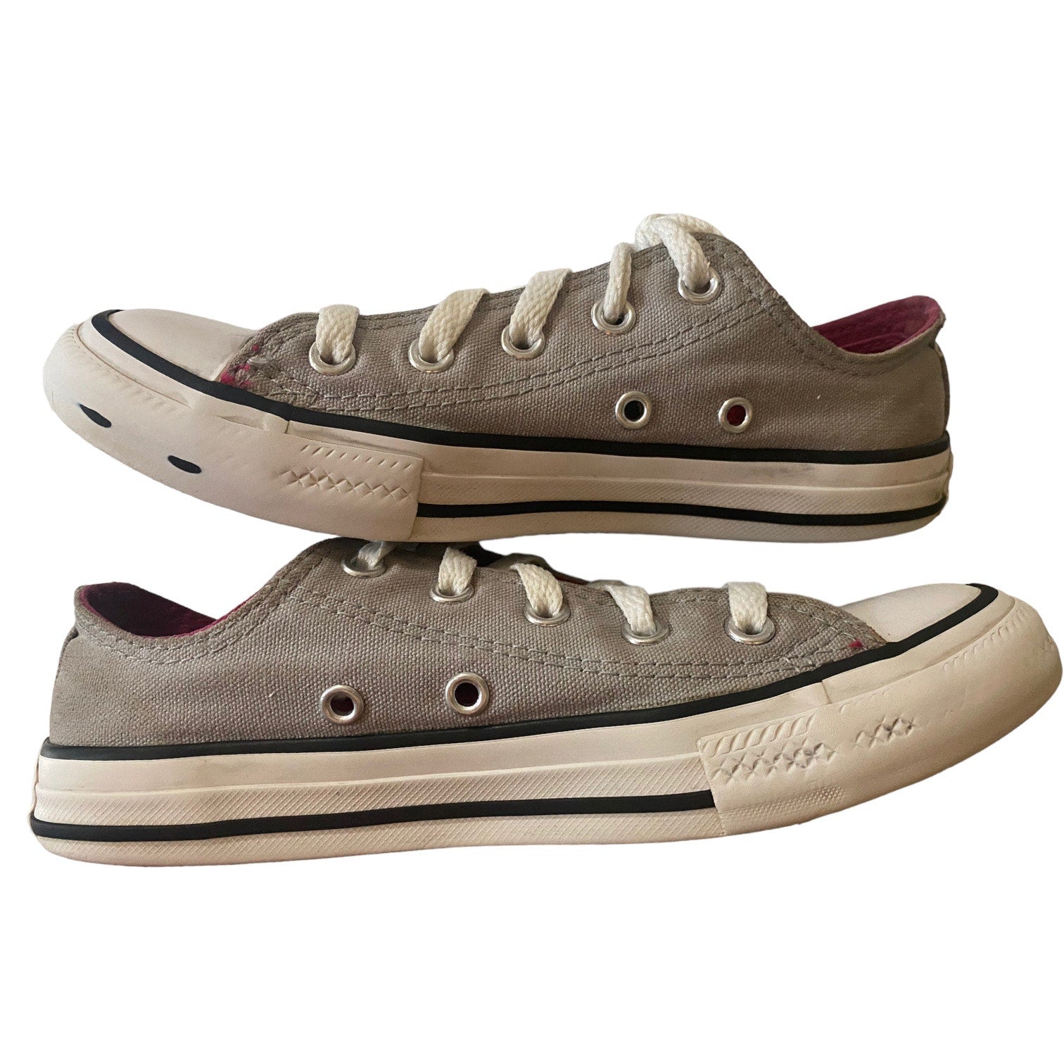 A pair of low-top canvas sneakers in a gray color, featuring white laces.