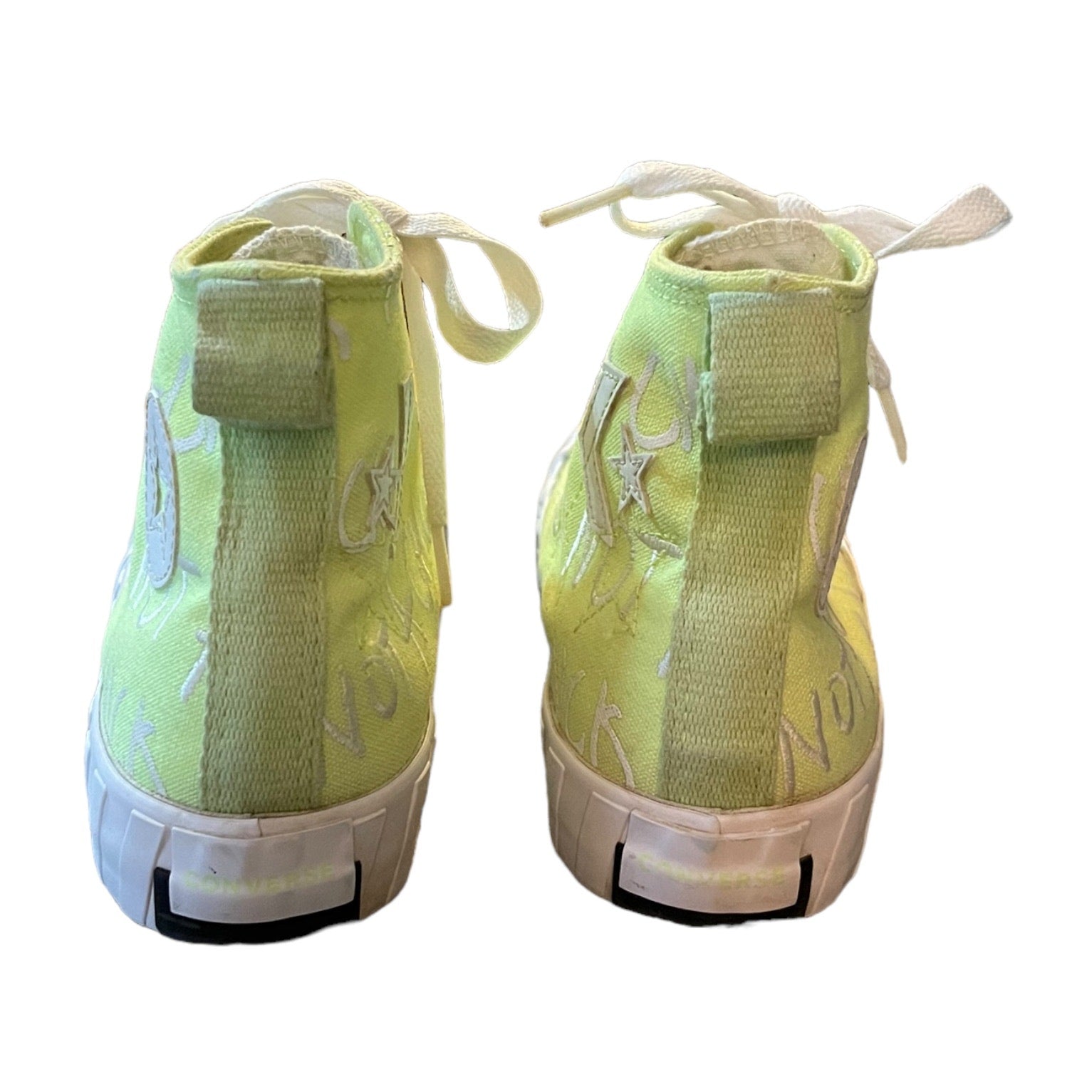 Pair of green high-top sneakers with white soles on a white background