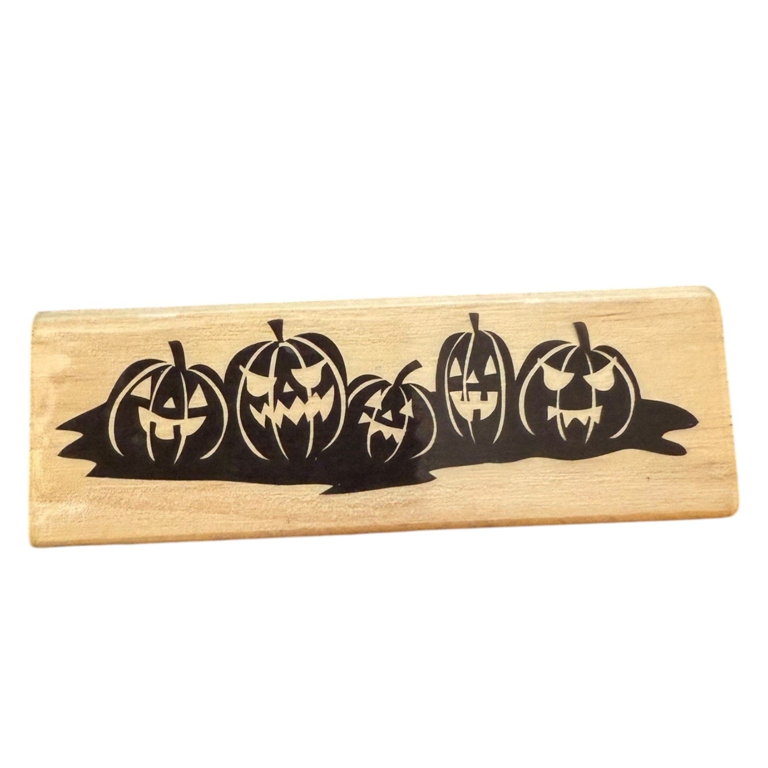 Wooden stamp with carved pumpkin design on a white background