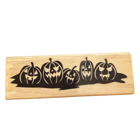 Wooden stamp with carved pumpkin design on a white background