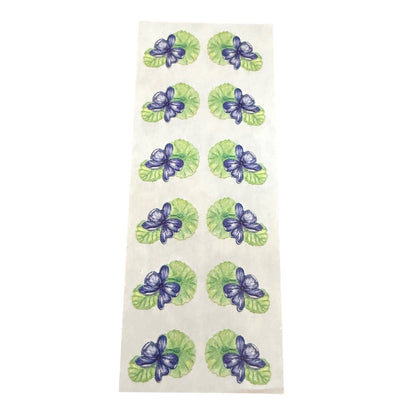 Green and purple floral stickers on a white sheet 