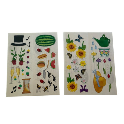 Two sheets of colorful stickers featuring various whimsical designs including sunflowers, watermelons, butterflies, a top hat, champagne glasses, and a green teapot on a white background.