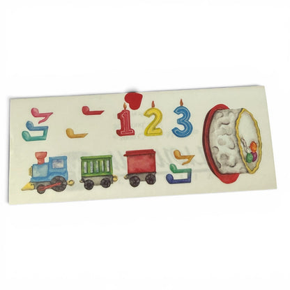Children's birthday cake topper with colorful train, candles, and moon design  stickers on a white background