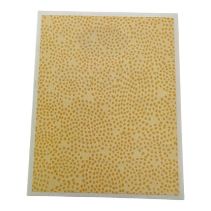 Yellow patterned sticker with a white border on a white background