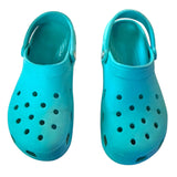 Top of a Pair of turquoise clogs on a white background