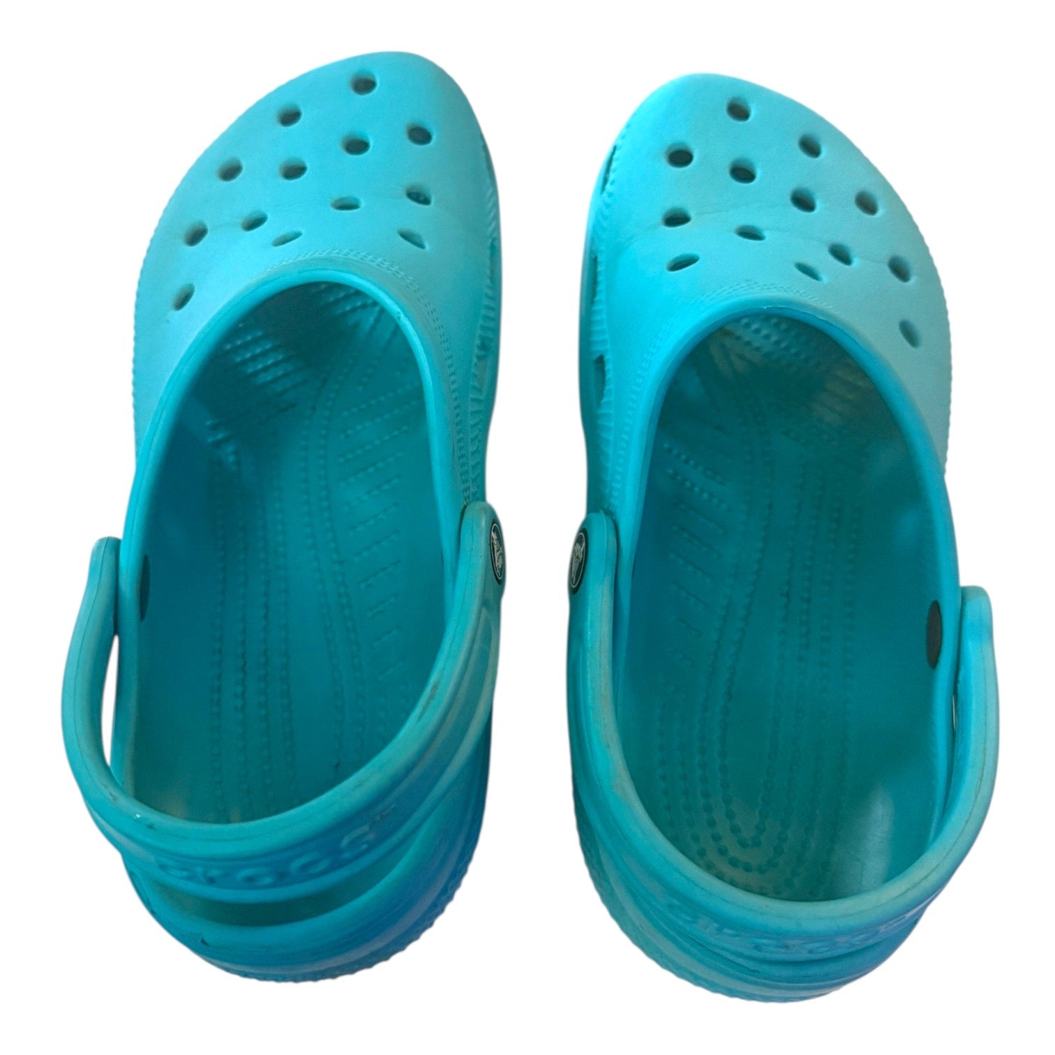 Top of a Pair of turquoise clogs on a white background