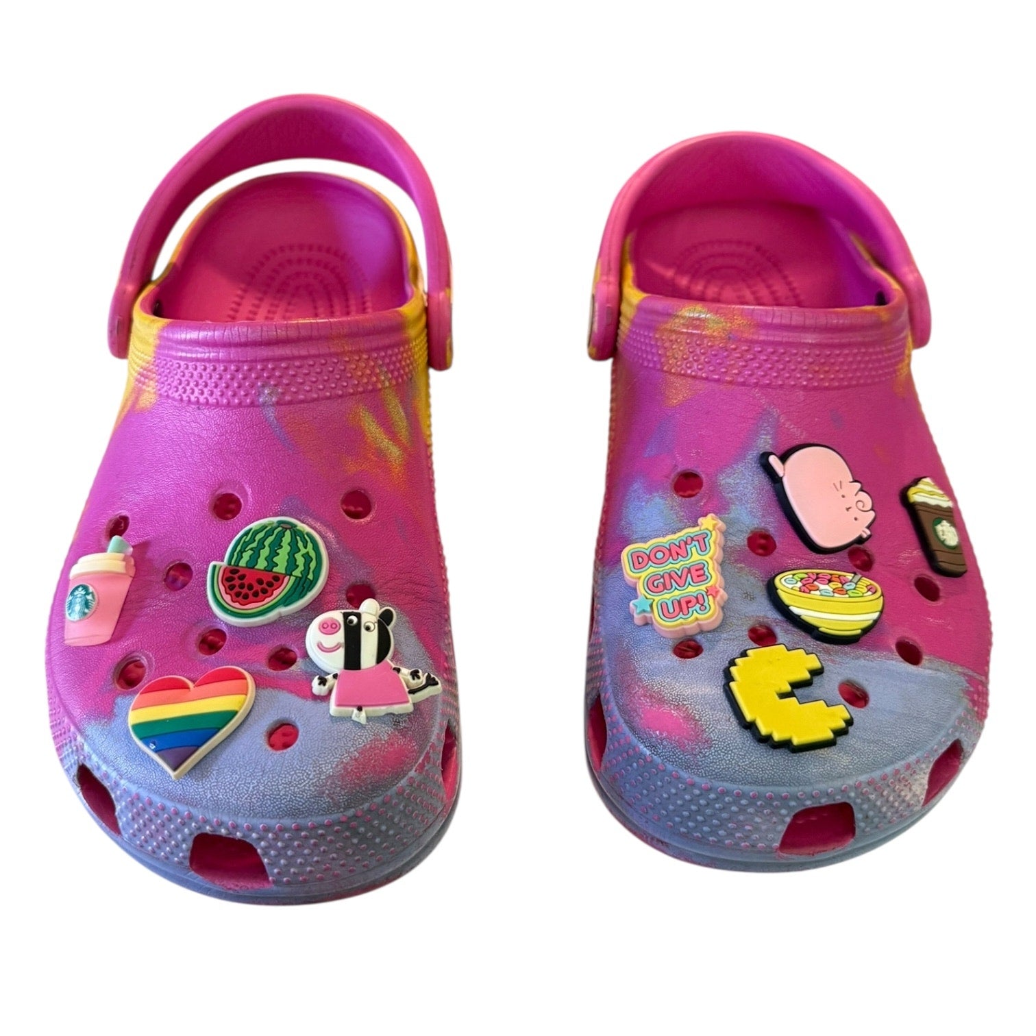 Front of clogs with various colorful charms on a white background