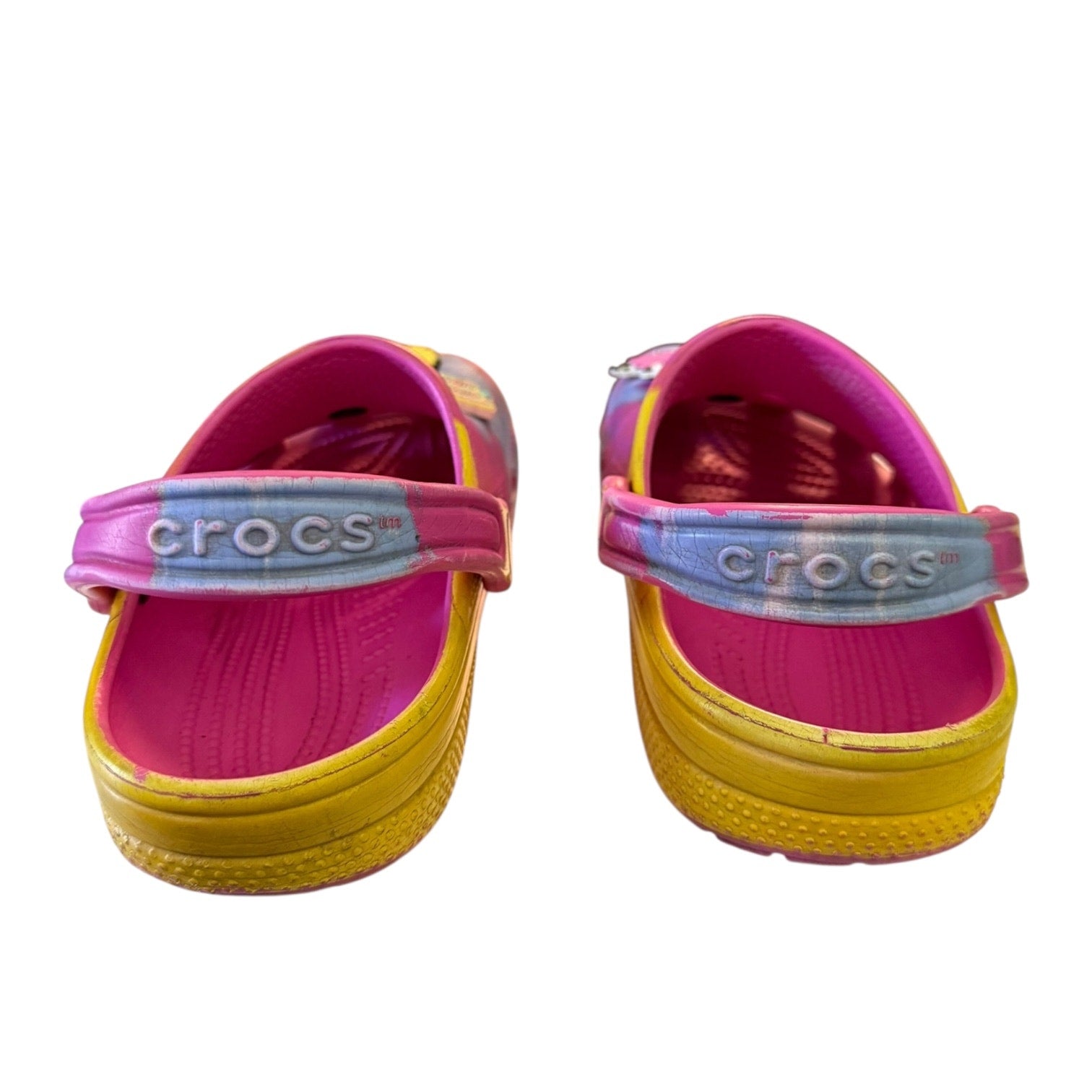Back of Pair of pink and yellow Crocs clogs on a white background