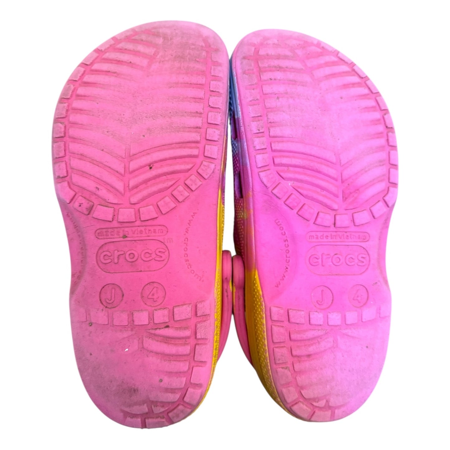 Close-up of pink Crocs shoes with sole texture on a white background