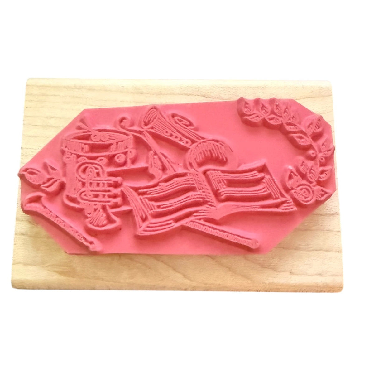 A pink rubber stamp mounted on a light-colored wooden block against a white background.