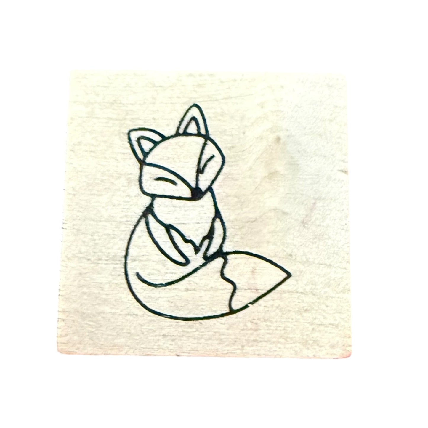 A square wooden stamp block featuring a fox, shown against a plain white background.