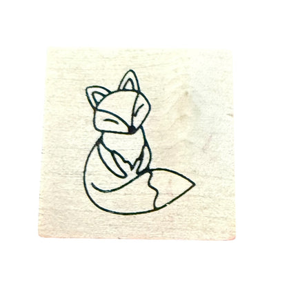 A square wooden stamp block featuring a fox, shown against a plain white background.