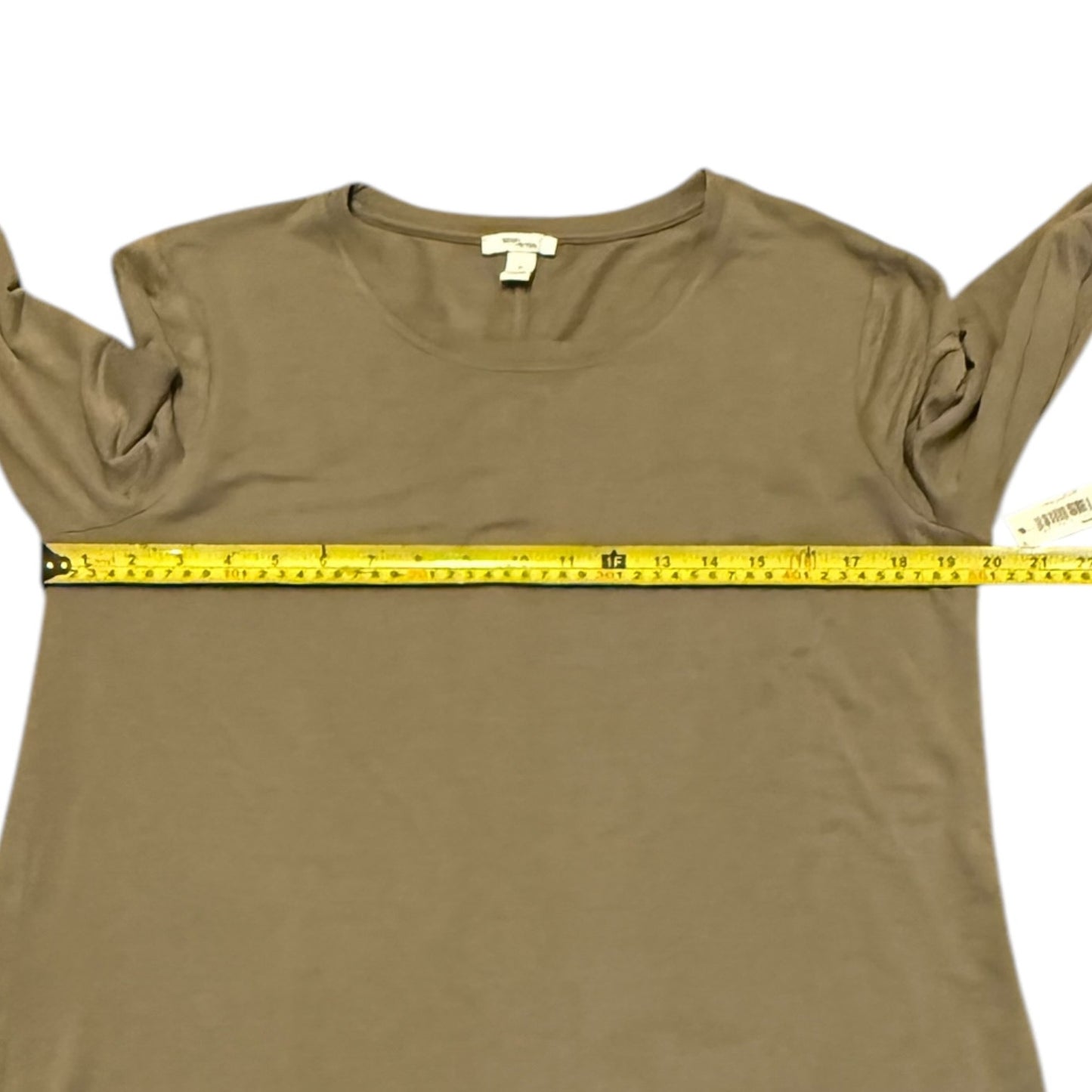Mocha shirt with measuring tape across it on a white background