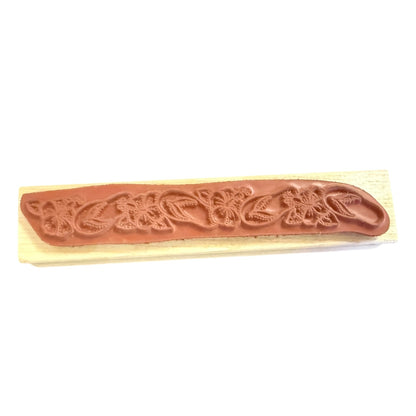 Decorative stamp with floral design on a wooden handle