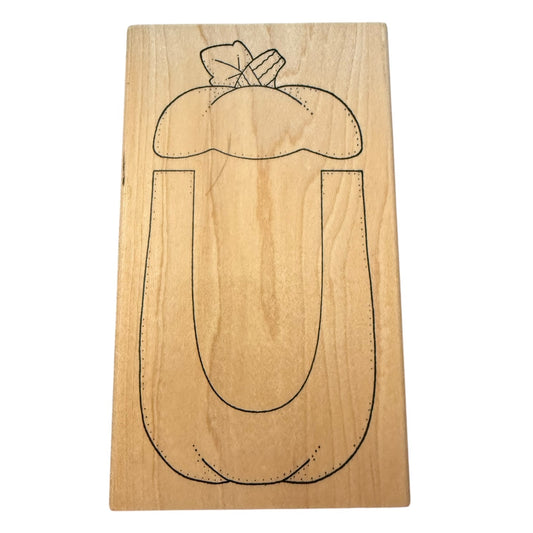 Wood block with a pumpkin carving template stamp on a white background