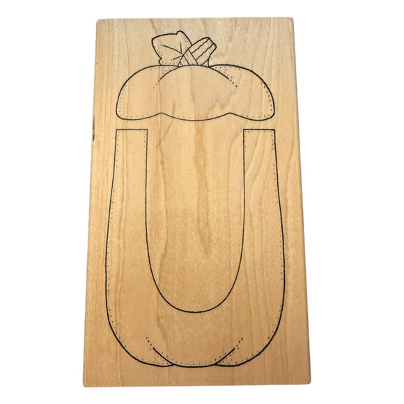 Wood block with a pumpkin carving template stamp on a white background