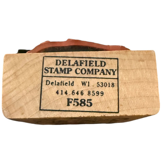 A wooden stamp block with black printed text reading 'DELAFIELD STAMP COMPANY' and 'F585' on a white background.