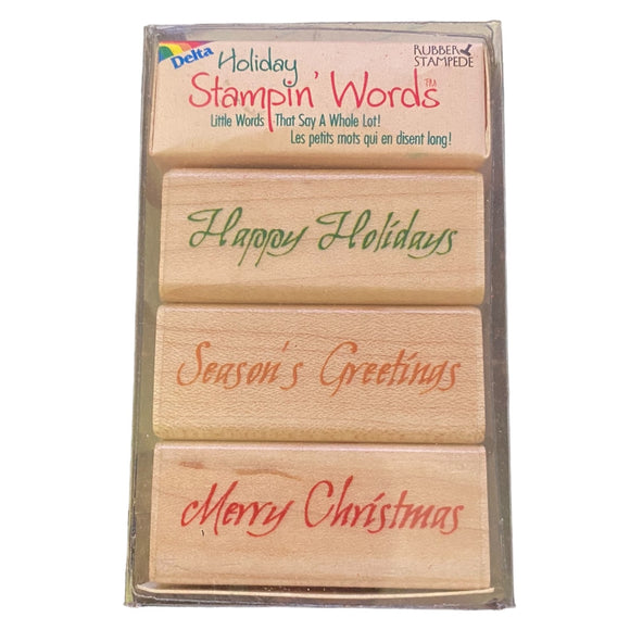 Set of rubber stamps with 'Happy Holidays', 'Season's Greetings', and 'Merry Christmas' text in a Delta Holiday Stampin' Words packaging.