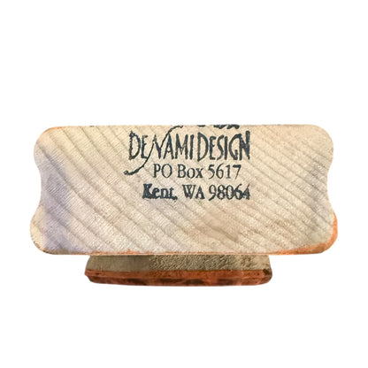 A rectangular wooden stamp block with rounded corners, black printed text reading 'DENAMI DESIGN PO Box 5617 Kent, WA 98064', shown on a plain white background.