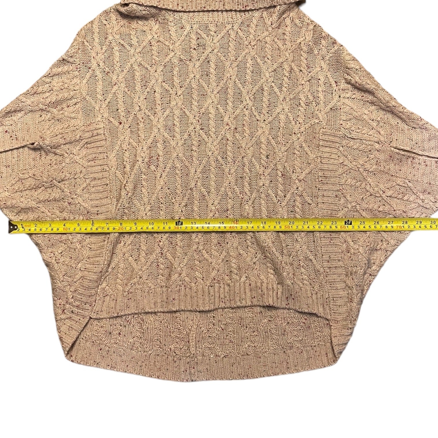 Sweater with a measuring tape for size reference on a white background