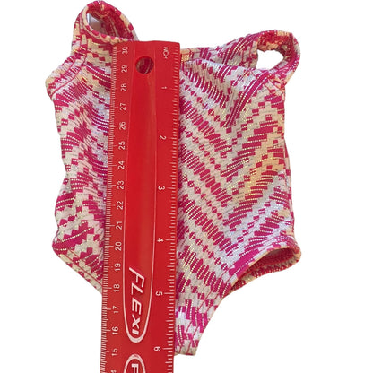 Pink and white patterned leotard with a red ruler for size reference on a white background