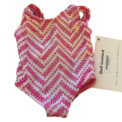 Pink and white patterned doll leotard with a label on a white background