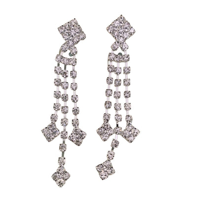 A pair of silver-toned dangle earrings embellished with clear rhinestones in a geometric, multi-tiered design, shown against a plain white background.