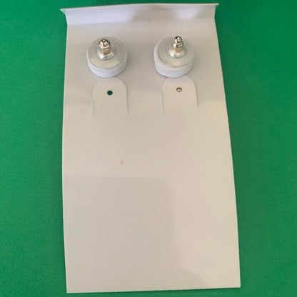 Back of a Pair of earrings on a white card with a green background