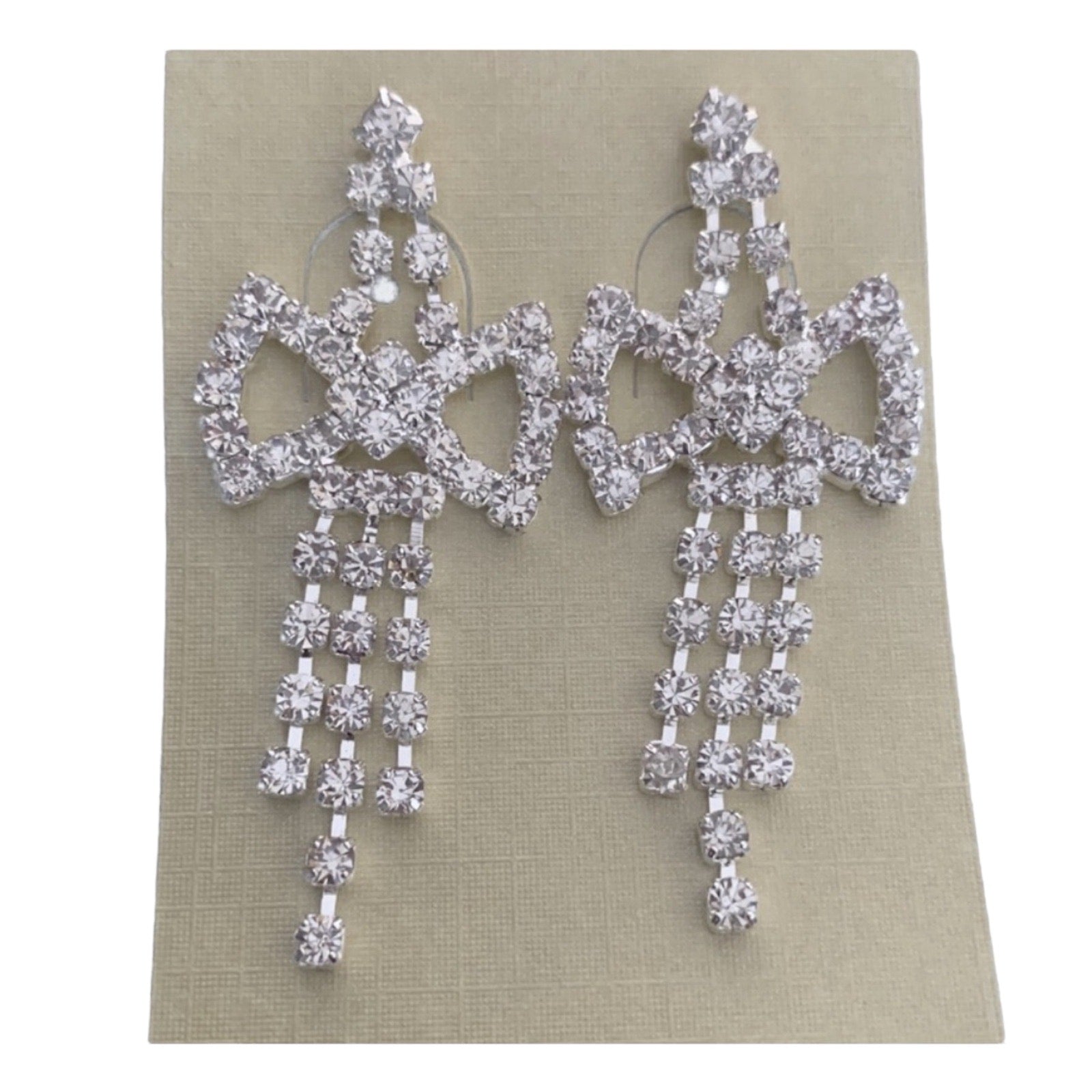 Pair of silver chandelier earrings on a beige card
