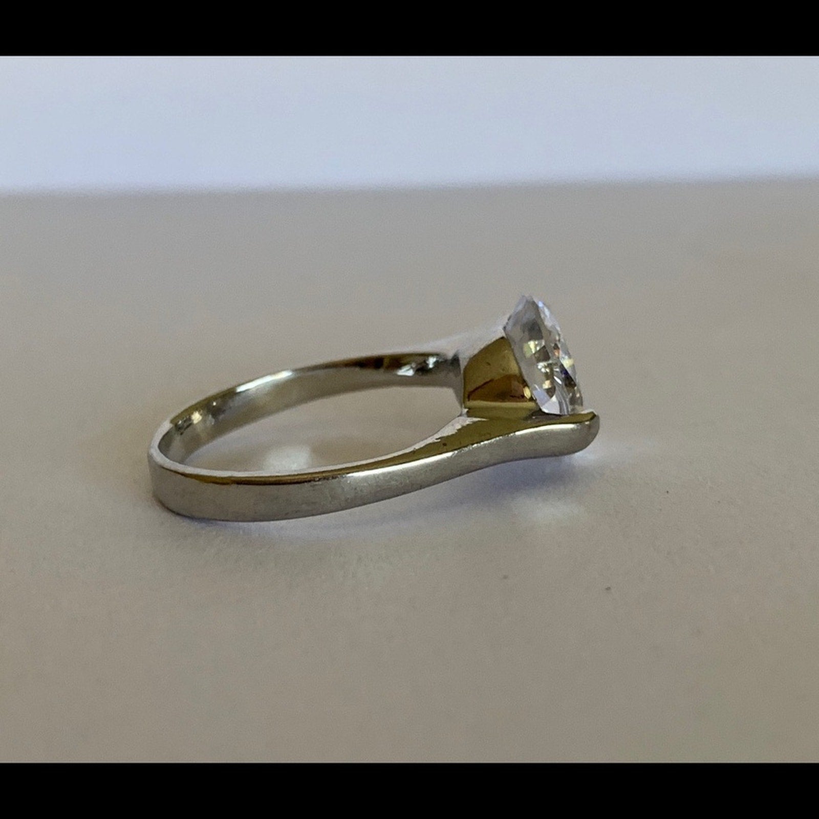 Side view of clear gemstone set in silver ring setting