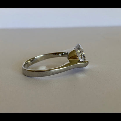 Side view of clear gemstone set in silver ring setting