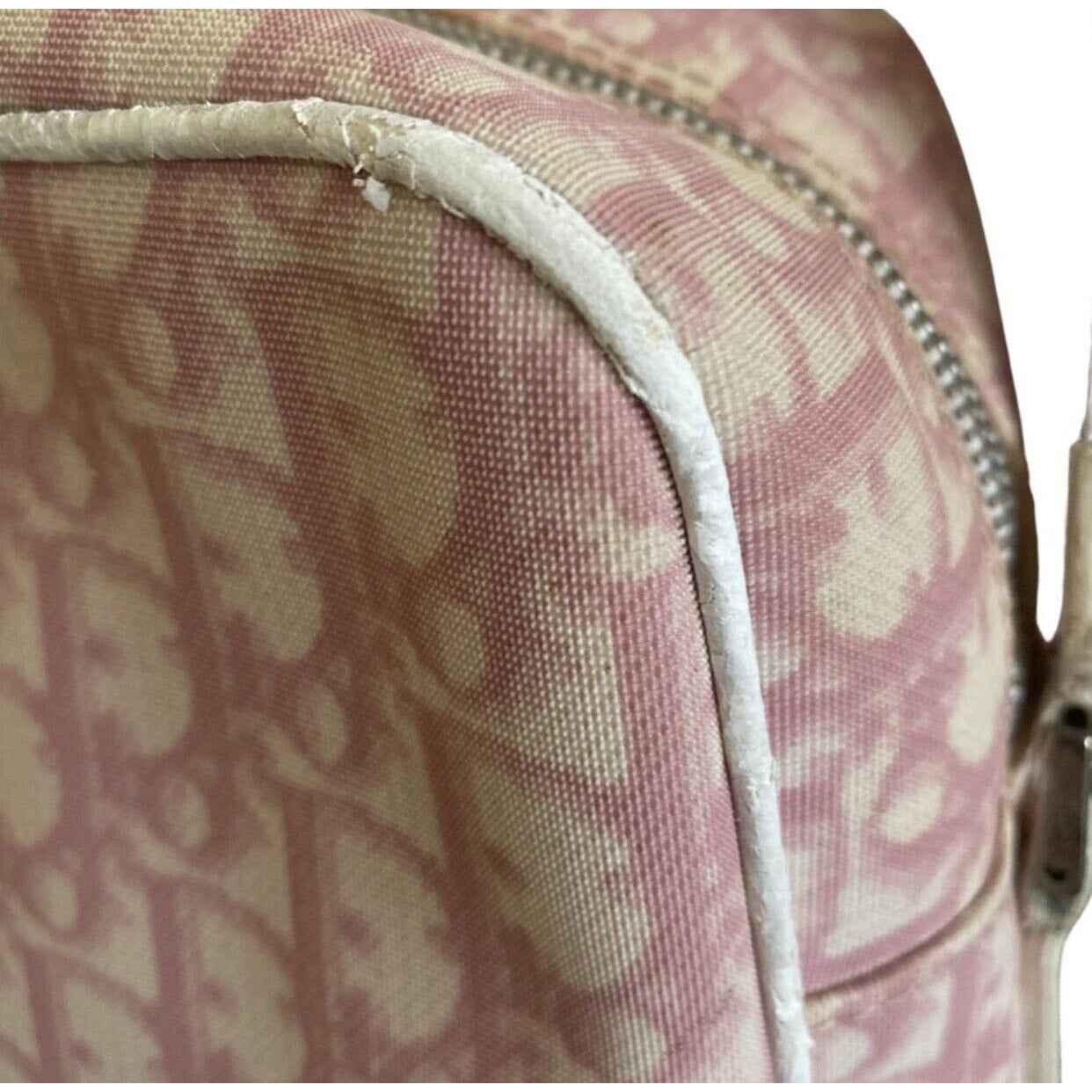 Close-up of a pink and white patterned bag with a visible brand logo and issues