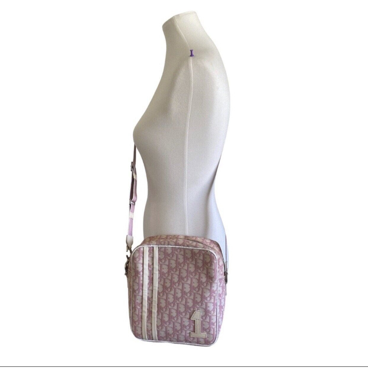 Mannequin wearing a pink and white patterned bag on a white background