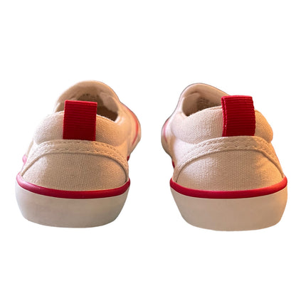 Back of a pair sneakers with red accents on a white background