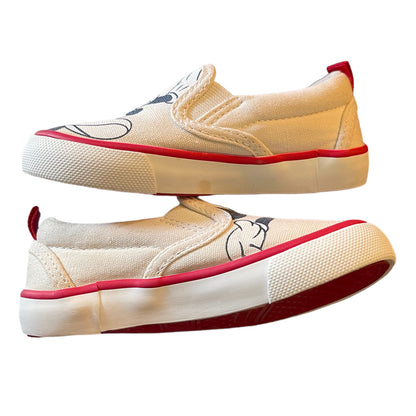 Side view of slip-on shoes with red soles on a white background