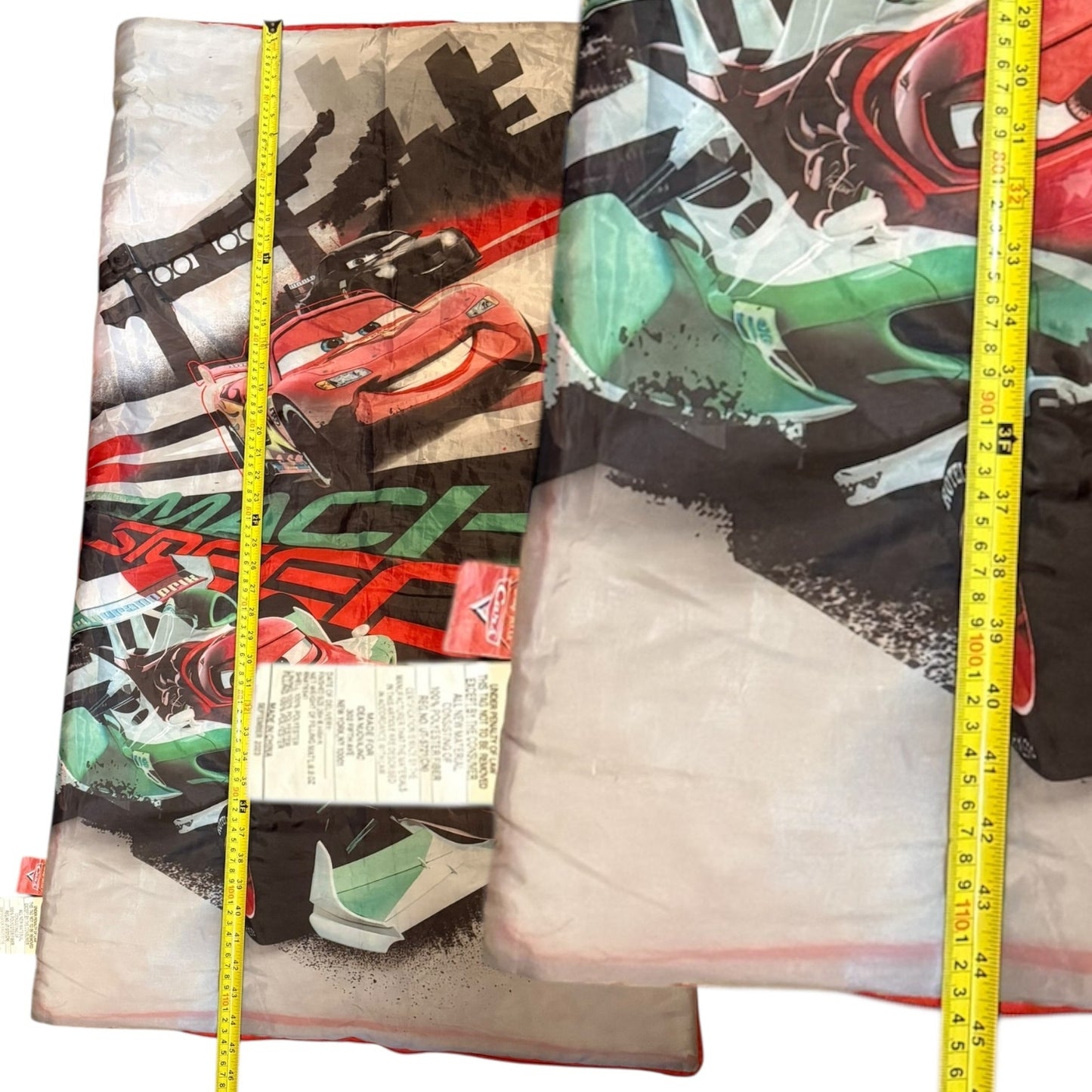 Sleeping bag car-themed prints and a measuring tape for scale.
