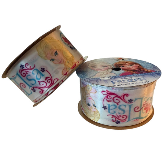 A spool of decorative ribbon featuring characters and logos from Disney's Frozen, shown on a plain white background with one spool standing upright and the other tilted beside it.