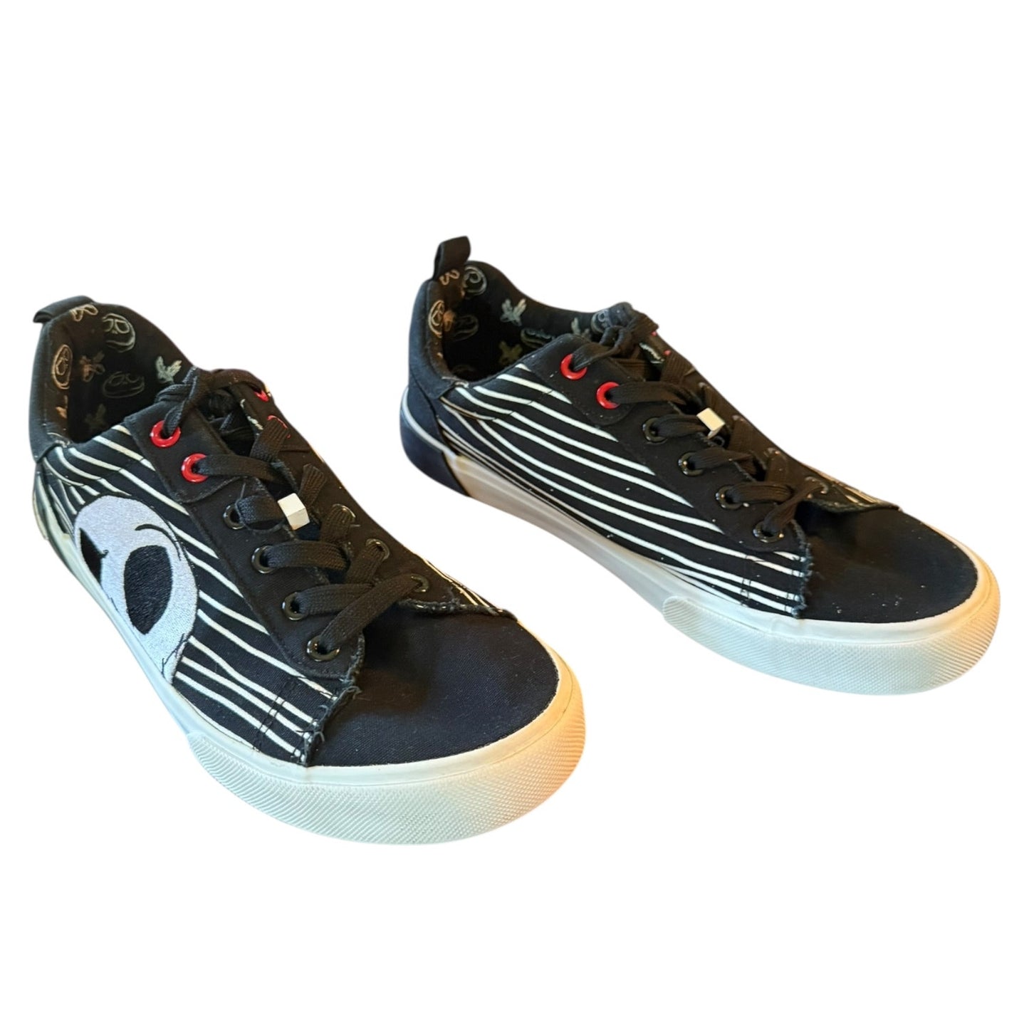 Black sneakers with white stripes and red accents on a white background