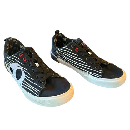Black sneakers with white stripes and red accents on a white background