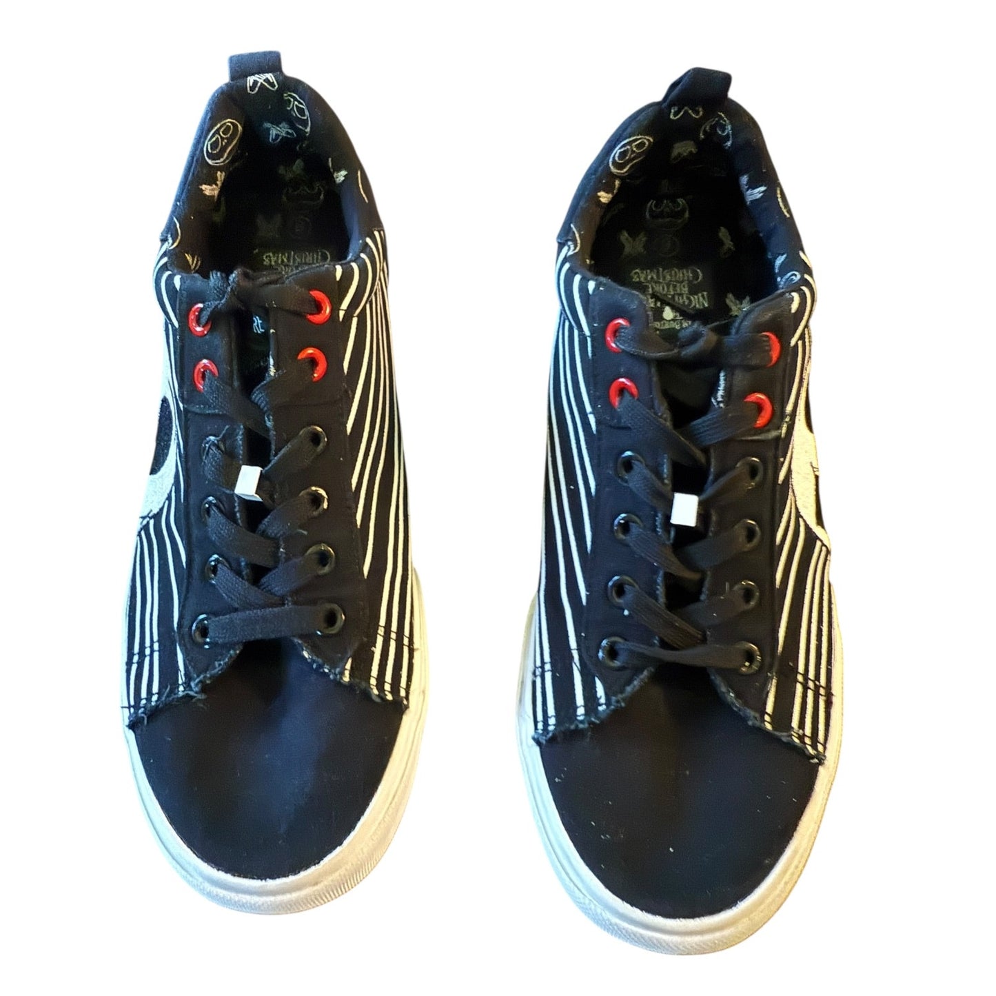 Pair of black and white sneakers with red accents on a white background