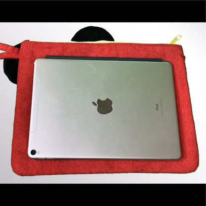 Silver ipad with Apple logo on top of a red pouch for size reference on a white background