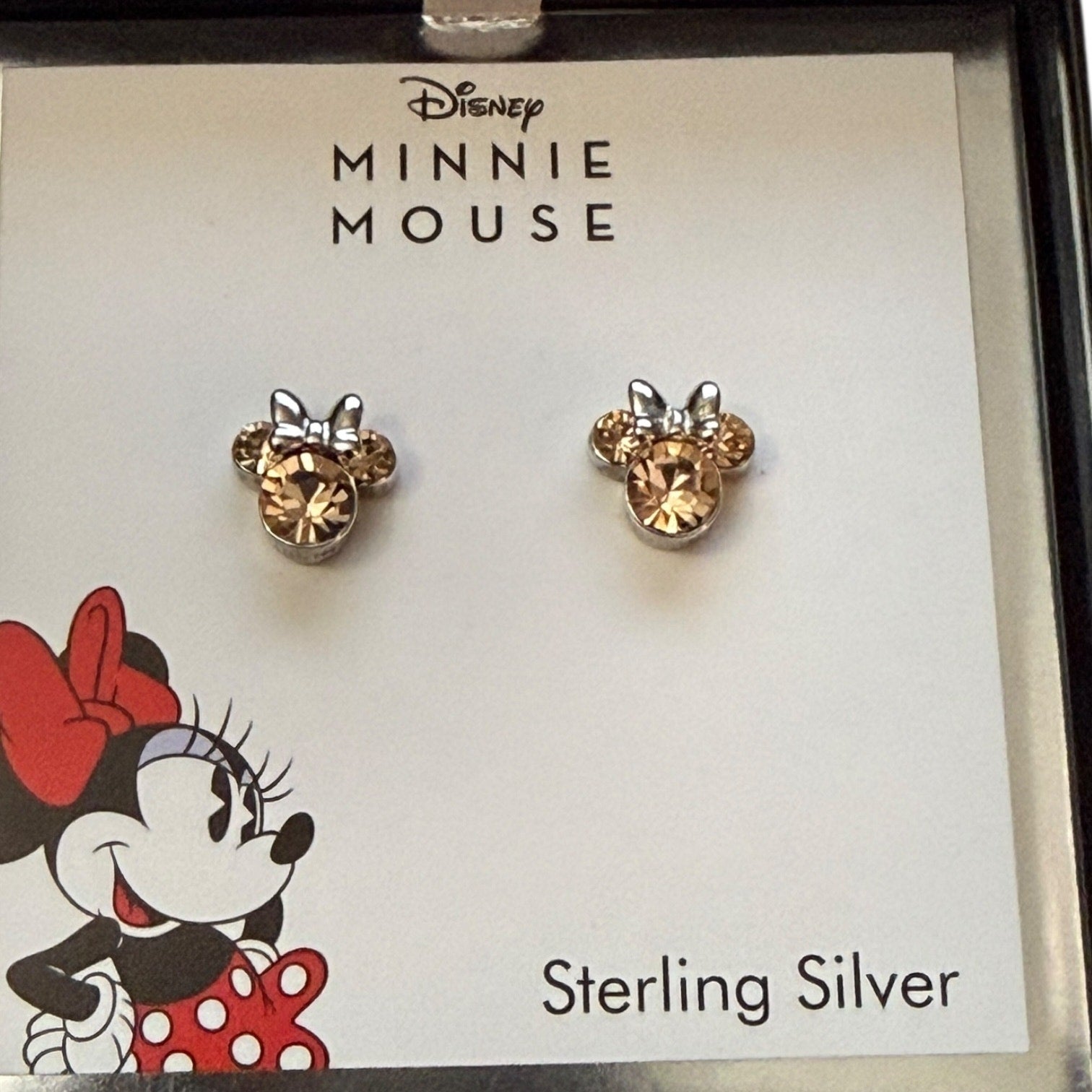 Minnie Mouse earrings on a branded card with Disney logo